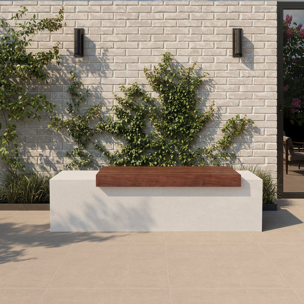 Tapered ModaCAST GFRC concrete bench in white with wood plank seat against a vine-covered brick wall