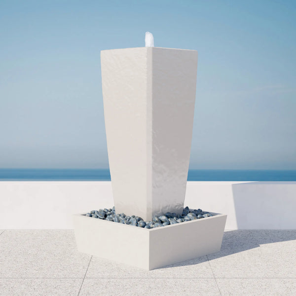 Vasa 52 in. ModaCAST StoneCast fountain, white, corner view with dark pebbles on a terrace